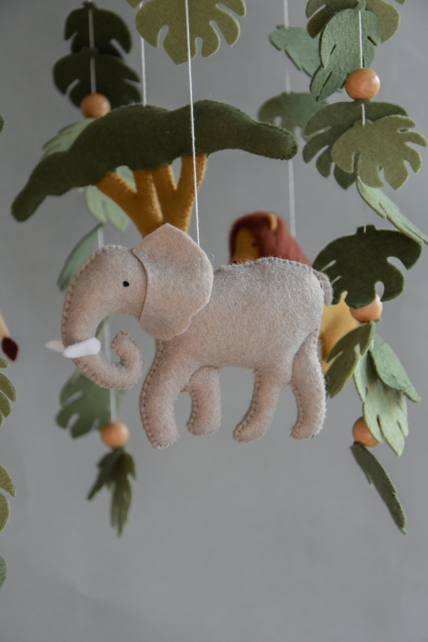 Safari mobile with felt, giraffe, lion, elephant, monstera leaves, tree and wooden pearls, different animals possible.