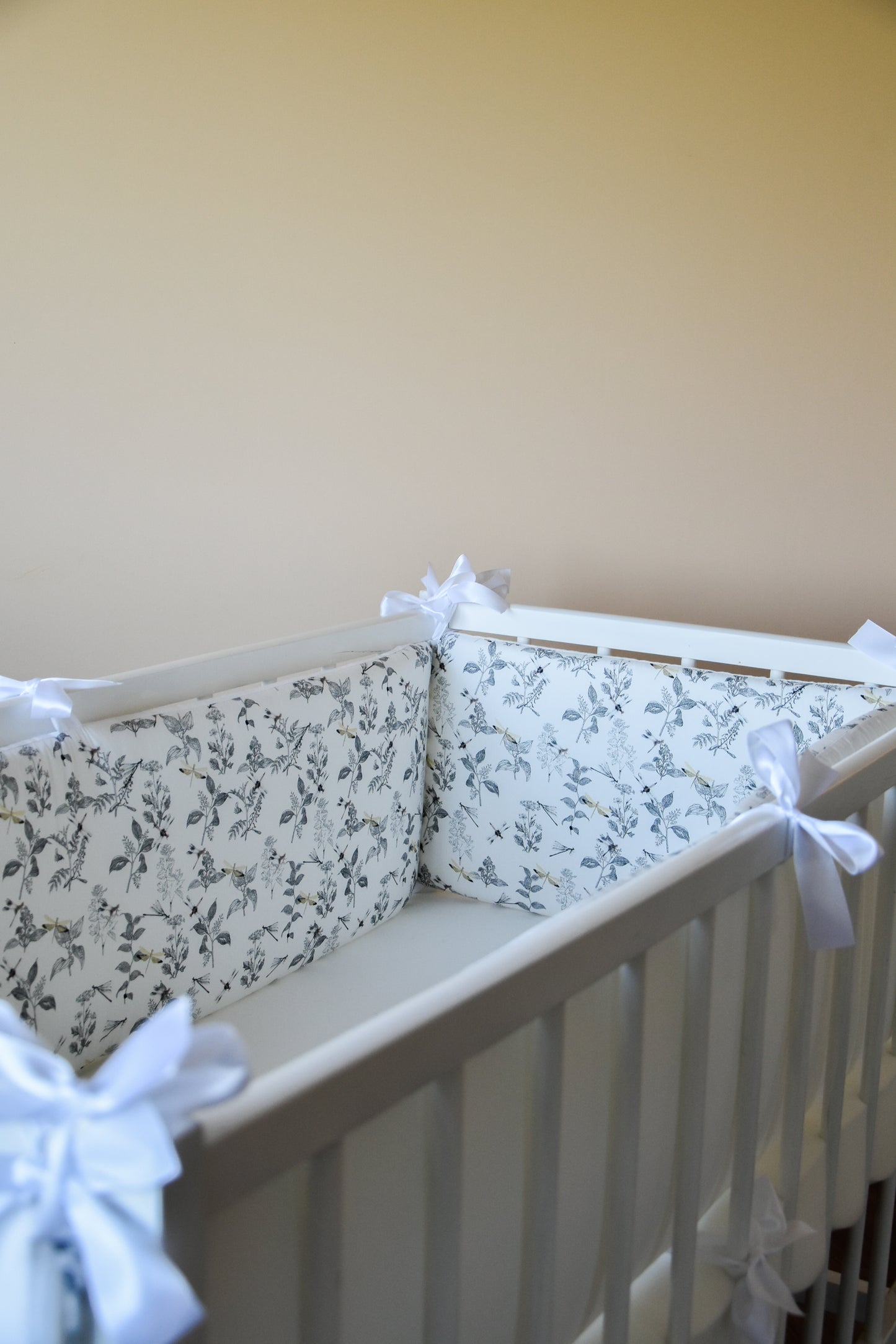 White crib bumper with with leaves and yellow wedges