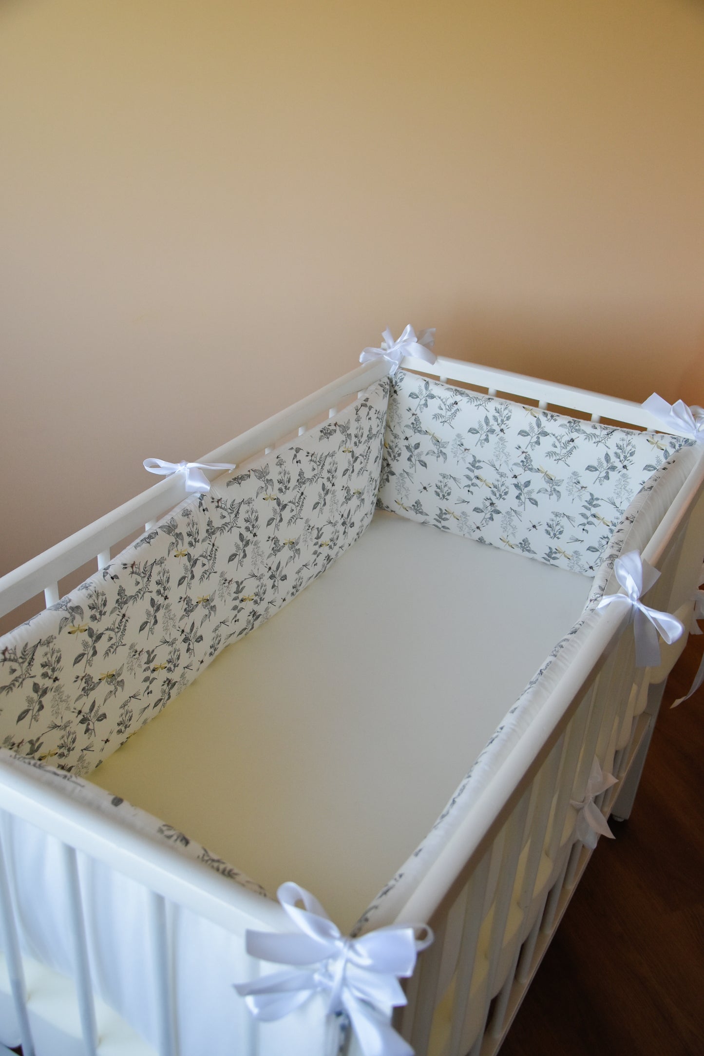 White crib bumper with with leaves and yellow wedges