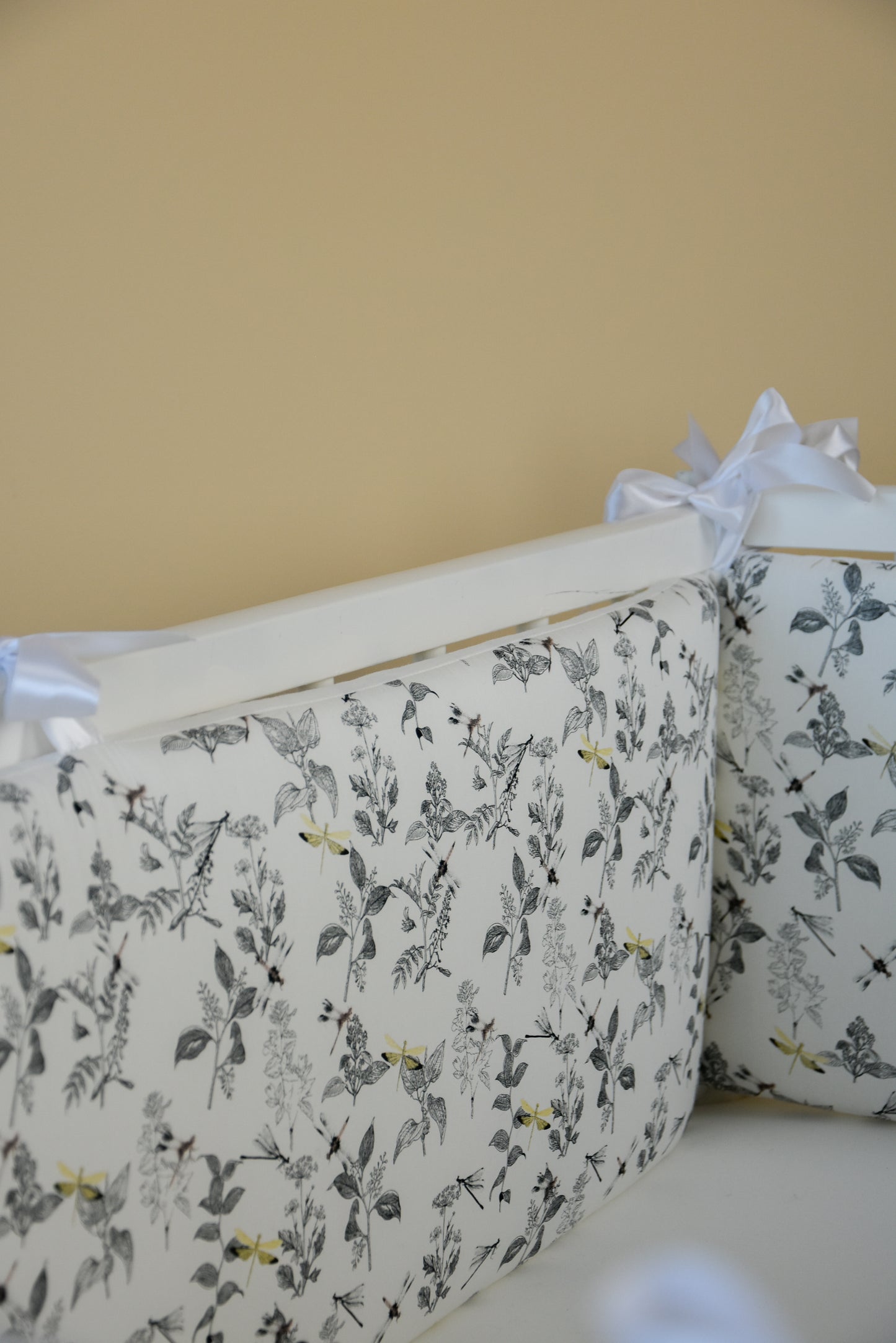 White crib bumper with with leaves and yellow wedges