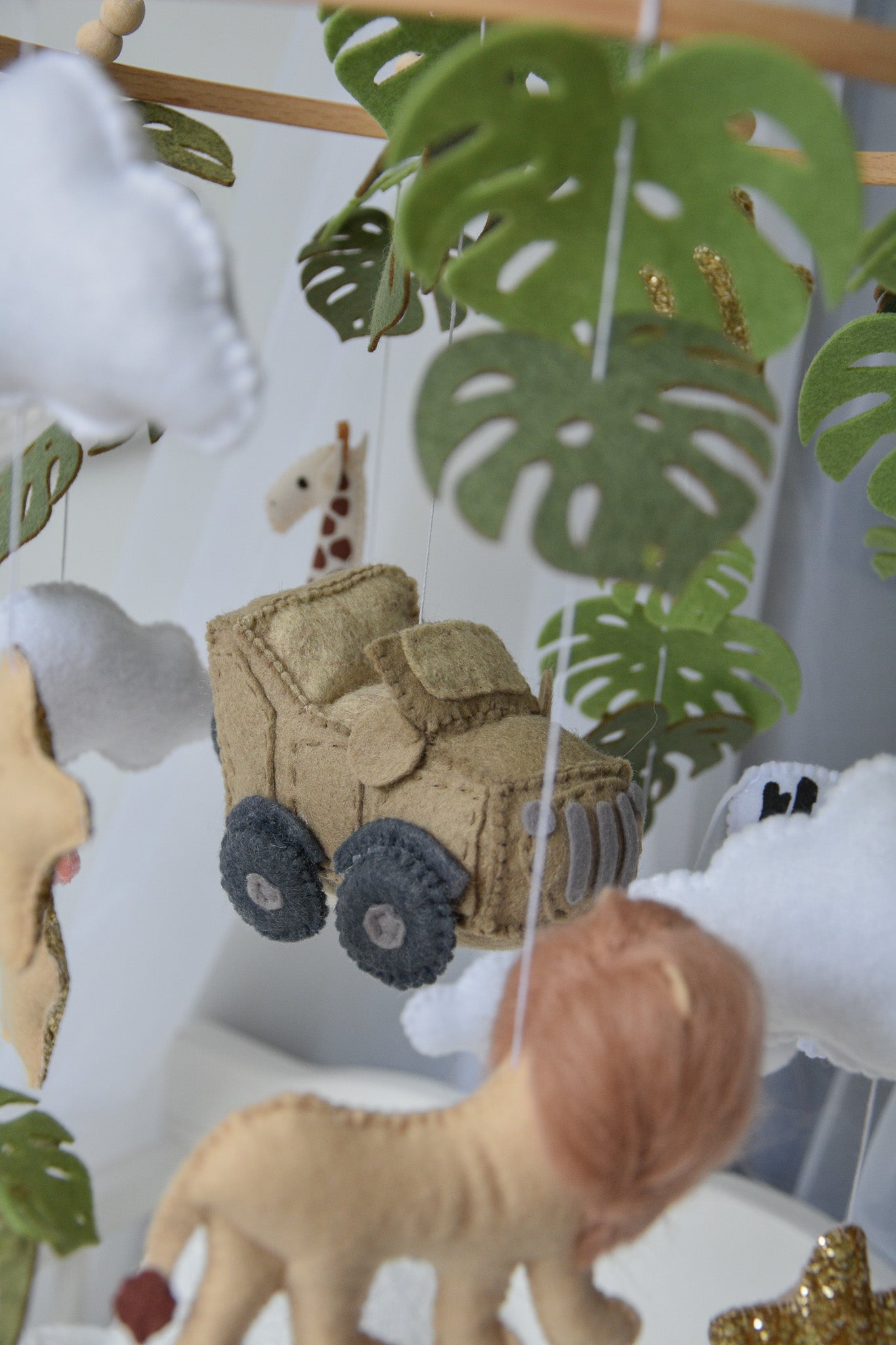 Safari mobile with offroad car, lion, zebra,, flamingos, elephants, monstera leaves, stars and clouds
