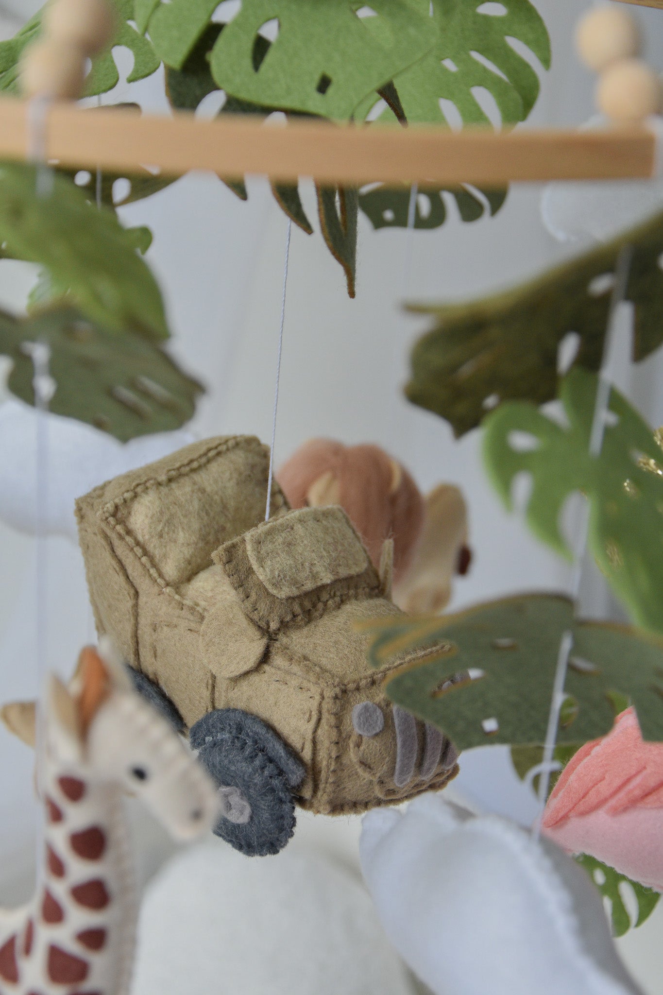 Safari mobile with offroad car, lion, zebra,, flamingos, elephants, monstera leaves, stars and clouds