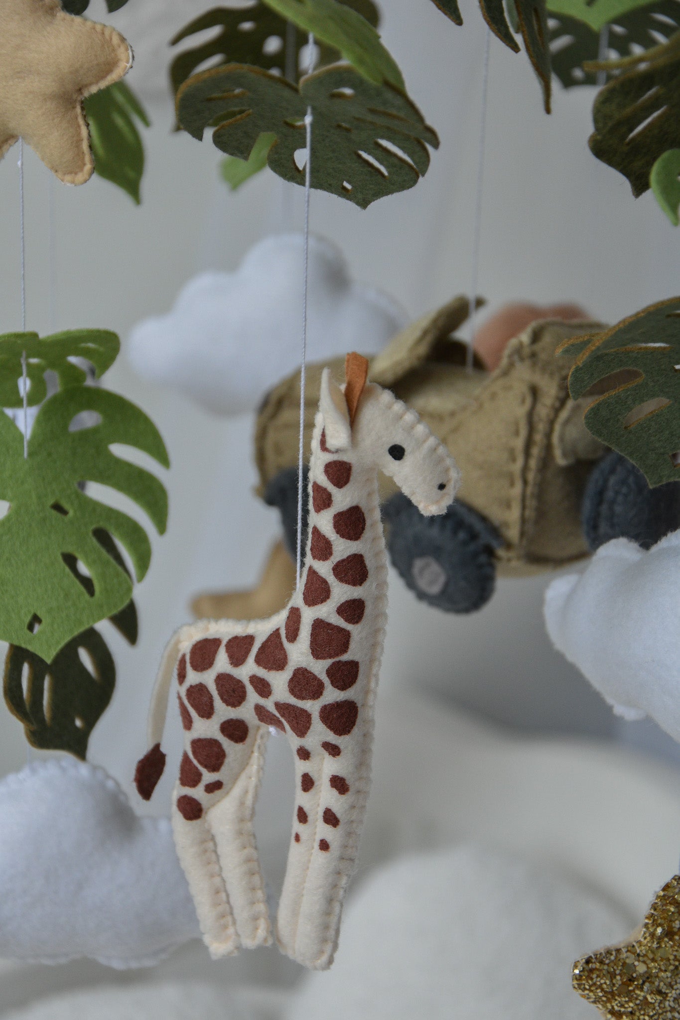 Safari mobile with offroad car, lion, zebra,, flamingos, elephants, monstera leaves, stars and clouds