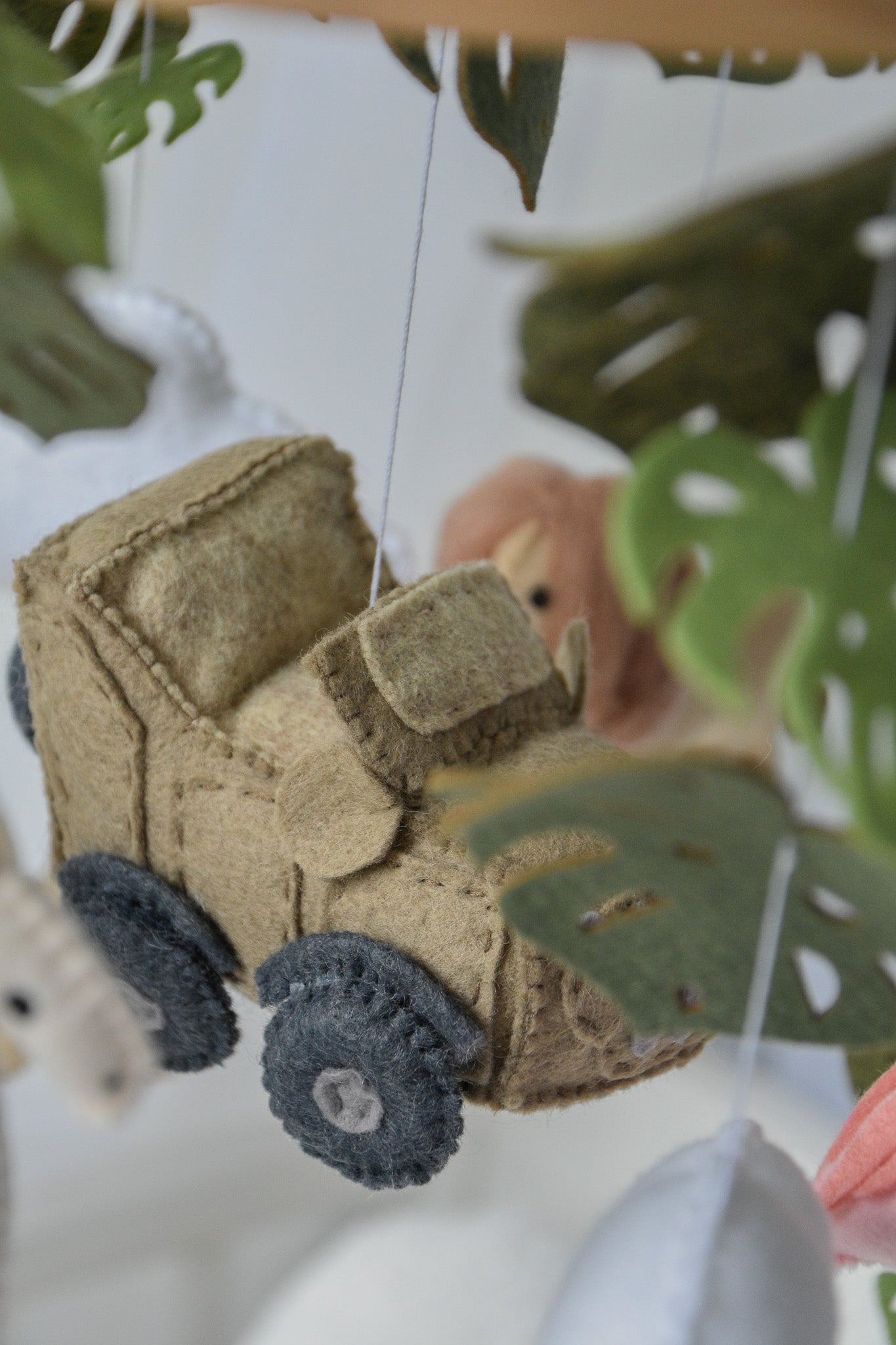 Safari mobile with offroad car, lion, zebra,, flamingos, elephants, monstera leaves, stars and clouds