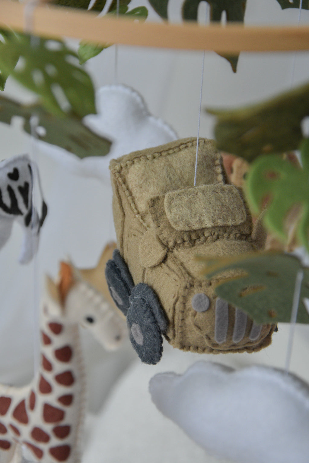 Safari mobile with offroad car, lion, zebra,, flamingos, elephants, monstera leaves, stars and clouds