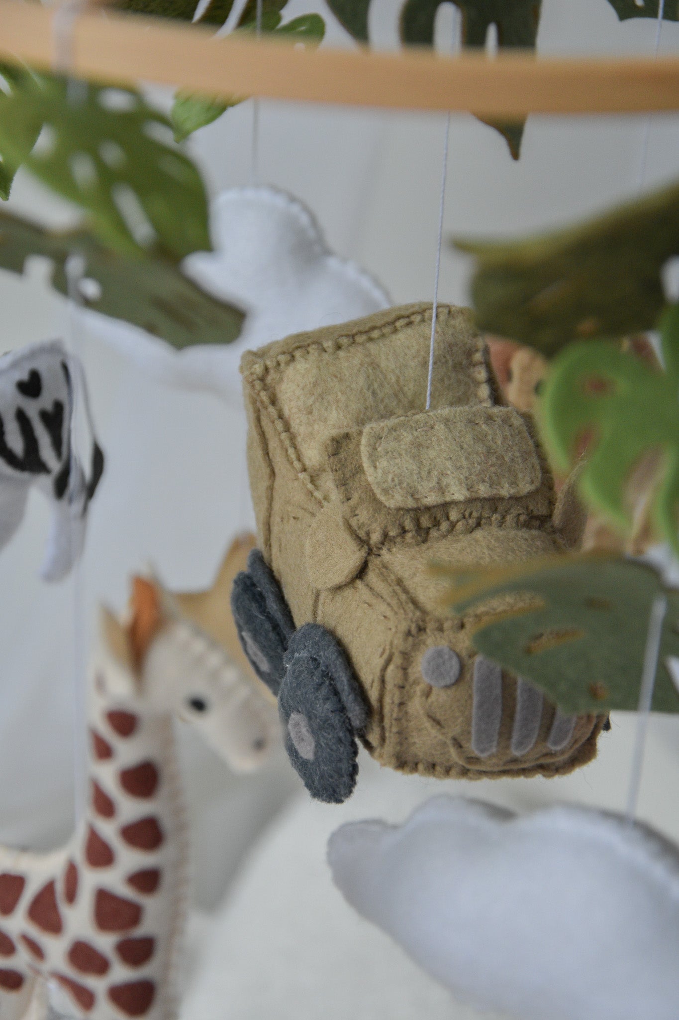 Safari mobile with offroad car, lion, zebra,, flamingos, elephants, monstera leaves, stars and clouds