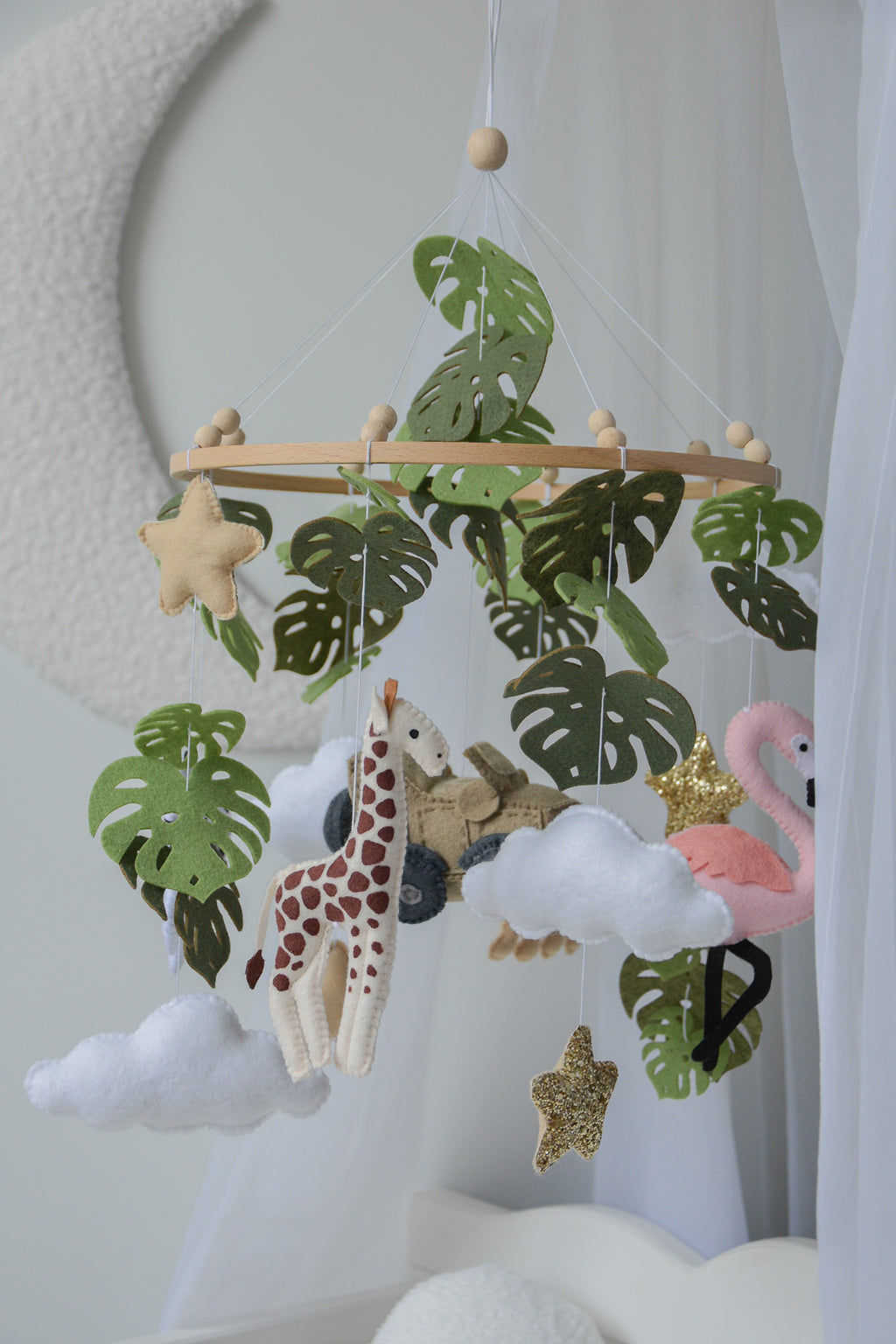 Safari mobile with offroad car, lion, zebra,, flamingos, elephants, monstera leaves, stars and clouds