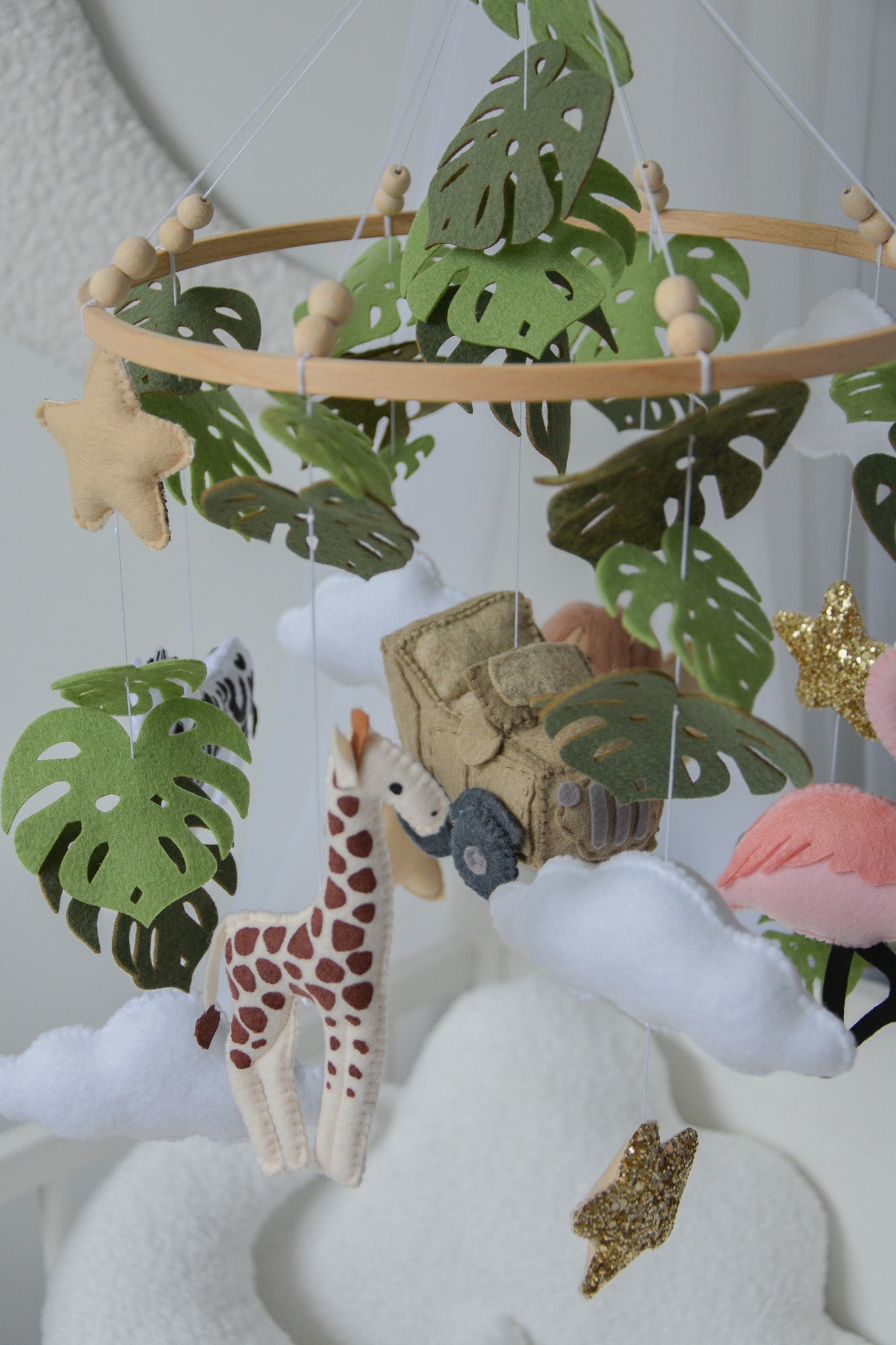 Safari mobile with offroad car, lion, zebra,, flamingos, elephants, monstera leaves, stars and clouds