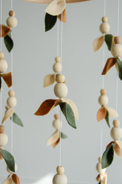 Floral mobile with wooden pearls, green, beige, brown and leaves